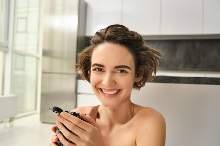 Foto grátis retrato de uma jovem feliz e em forma fazendo exercícios esportivos em casa bebe água de garrafa e sm