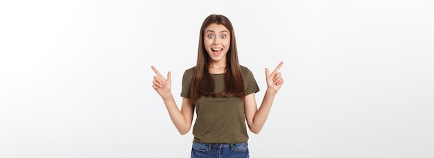 Retrato de uma jovem feliz e surpresa em pé isolada sobre fundo cinza olhando a câmera pointi