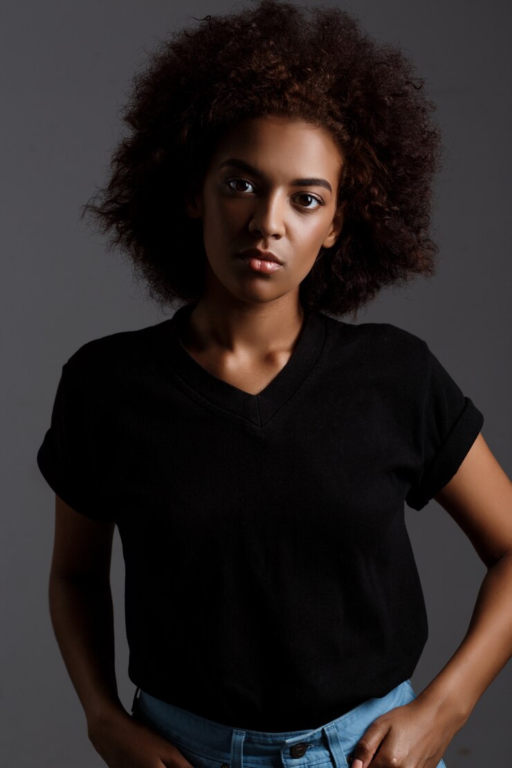 Foto grátis retrato de uma jovem garota africana bonita parede escura