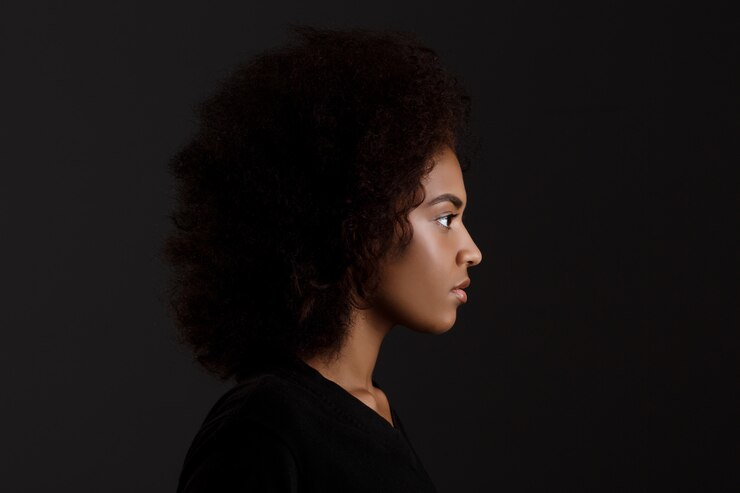 Foto grátis retrato de uma jovem garota africana bonita parede escura