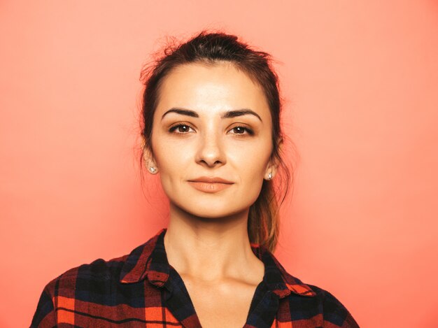 Retrato de uma jovem garota bonita sorridente hipster em roupas da moda jeans e camisa quadriculada de verão
