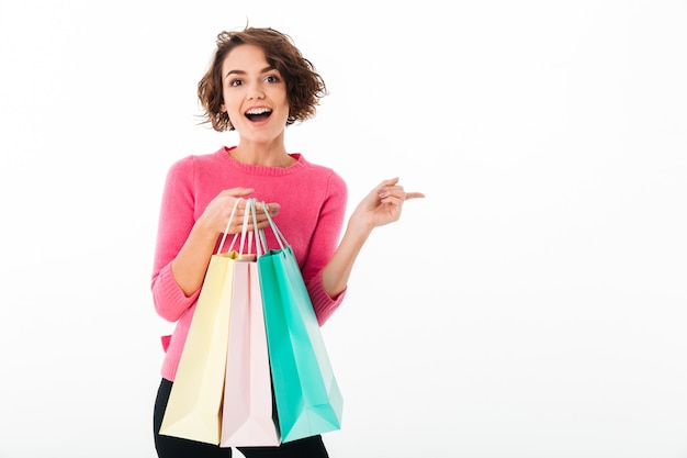Retrato de uma jovem garota feliz segurando sacolas de compras