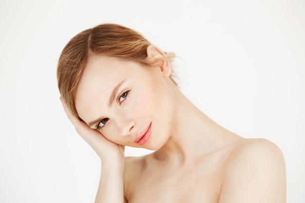 Retrato de uma jovem garota linda tocando o rosto. tratamento facial. produtos de beleza e cuidados com a pele.