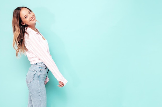 Foto grátis retrato de uma jovem linda mulher sorridente em roupas da moda de verão mulher despreocupada sexy posando perto da parede azul no estúdio modelo positivo se divertindo dentro de casa alegre e feliz