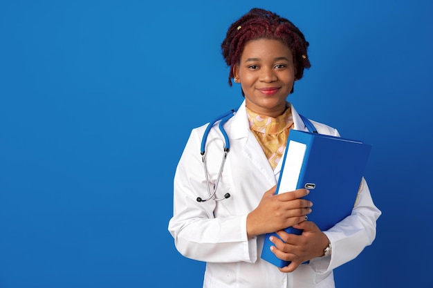 Retrato de uma jovem médica afro-americana contra um fundo azul.