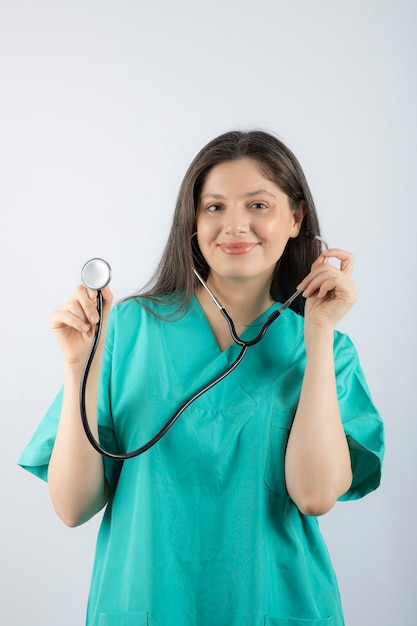 Retrato de uma jovem médica com estetoscópio de uniforme.