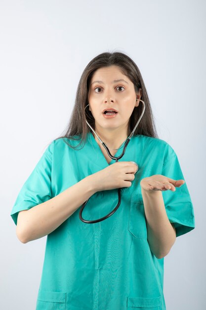 Retrato de uma jovem médica com estetoscópio de uniforme.