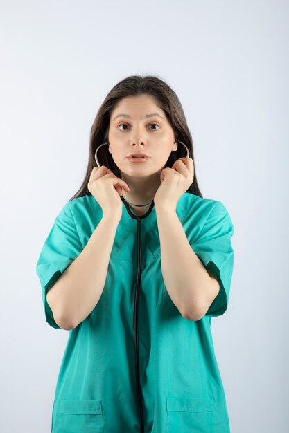 Retrato de uma jovem médica com estetoscópio de uniforme.