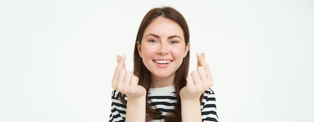 Foto grátis retrato de uma jovem morena bonita mostra corações de dedo kawaii e sorrindo gosta de smth