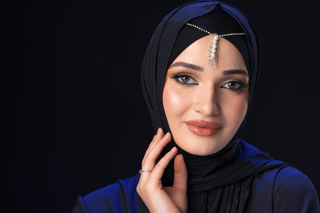Retrato de uma jovem muçulmana em hijab em fundo preto