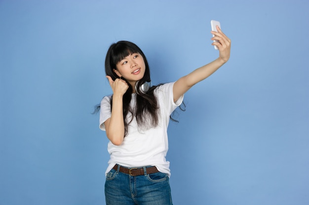 Retrato de uma jovem mulher asiática isolada no espaço azul studio