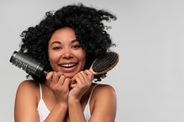 Retrato de uma jovem mulher bonita com escova de cabelo