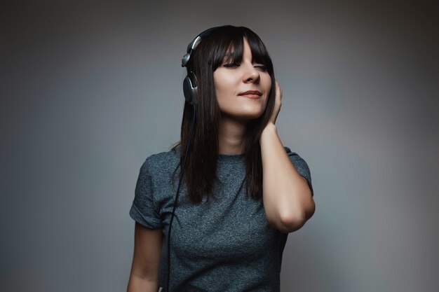 Foto grátis retrato de uma jovem mulher bonita com fones de ouvido