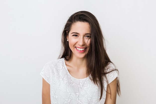 Retrato de uma jovem mulher bonita sorrindo em camiseta branca, feliz, humor positivo, isolado, sorriso sincero, cabelos longos