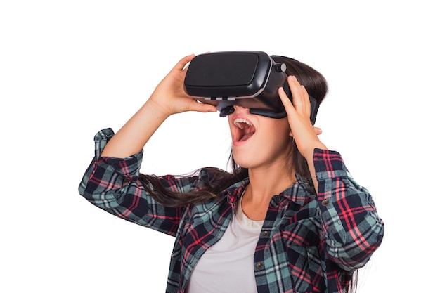Retrato de uma jovem mulher brincando com óculos de fone de ouvido Vr de realidade virtual isolada no estúdio. Dispositivo de óculos de fone de ouvido VR. Conceito de tecnologia.