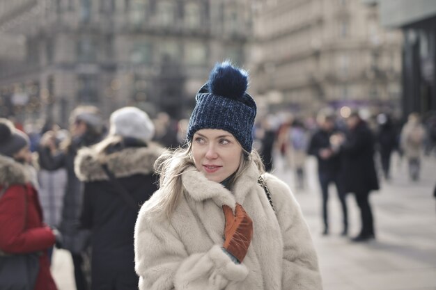 Retrato de uma jovem mulher europeia com um casaco de pele e um chapéu ao ar livre