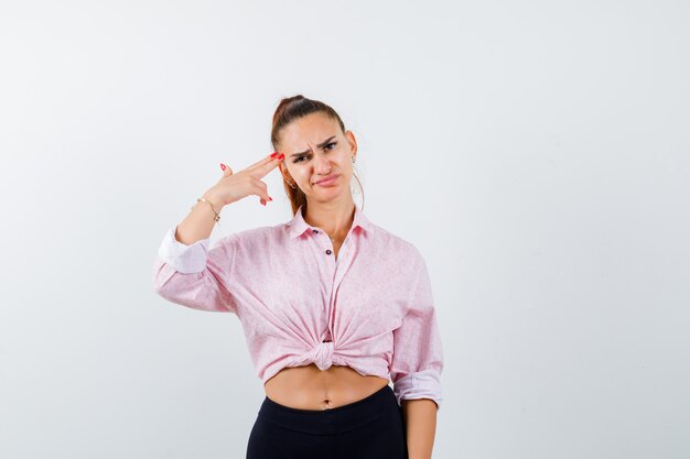 Foto grátis retrato de uma jovem mulher fazendo gesto de suicídio com uma camisa casual