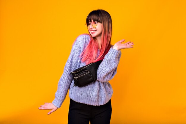 retrato de uma jovem mulher feliz, emoções positivas saiu, cabelos fúcsia na moda brilhantes, camisola aconchegante, calças e bolsa de bumbum.