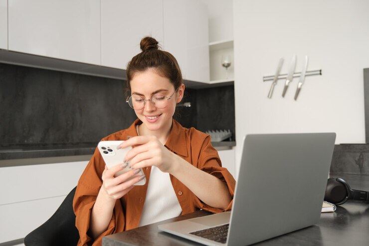 Foto grátis retrato de uma jovem mulher freelancer que trabalha em casa com uma programadora de laptop sentada com