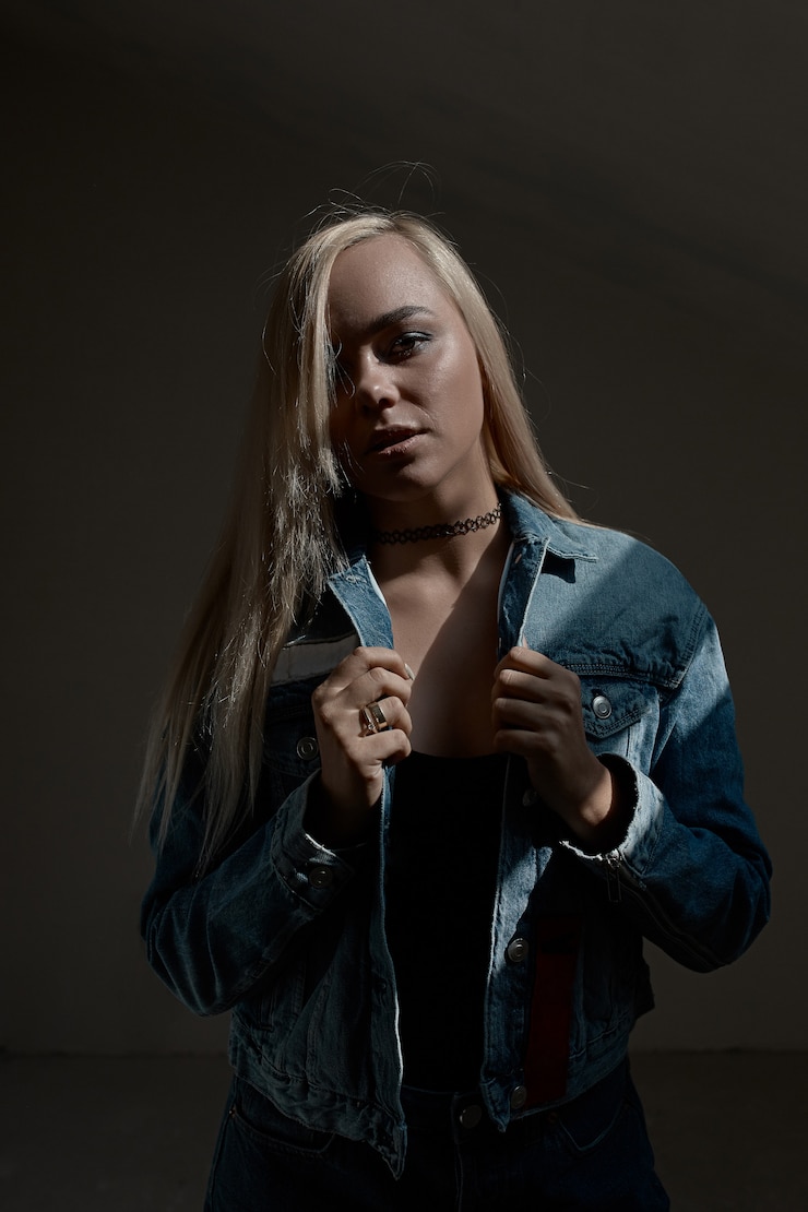 Foto grátis retrato de uma jovem mulher loira na parede escura