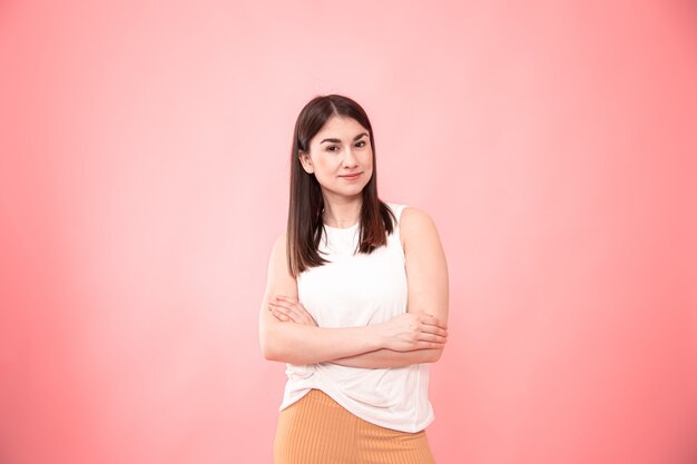 Retrato de uma jovem mulher mostrando emoções onn isolado rosa.