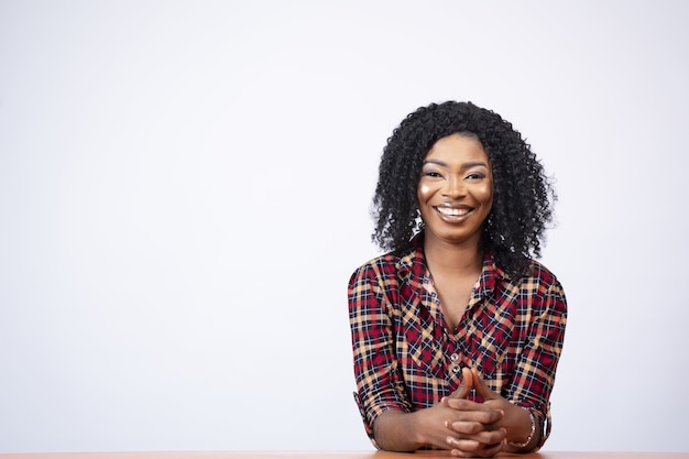 Foto grátis retrato de uma jovem mulher negra sentada em uma mesa