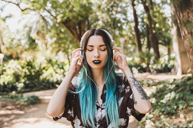 Retrato de uma jovem mulher ouvindo música no fone de ouvido