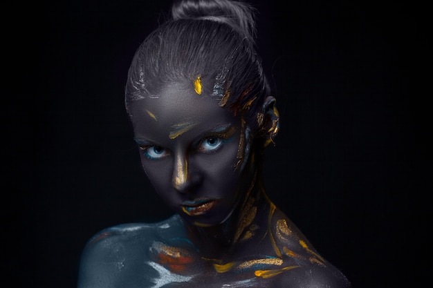 Retrato de uma jovem mulher que posa coberta com tinta preta