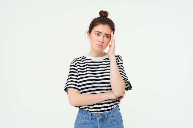 Foto grátis retrato de uma jovem preocupada preocupada toca sua cabeça olhando complicado de pé sobre branco