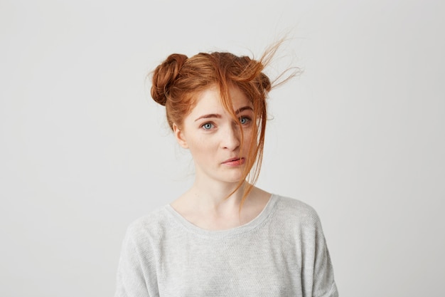 Retrato de uma jovem ruiva linda com bolo de cabelo mimado.