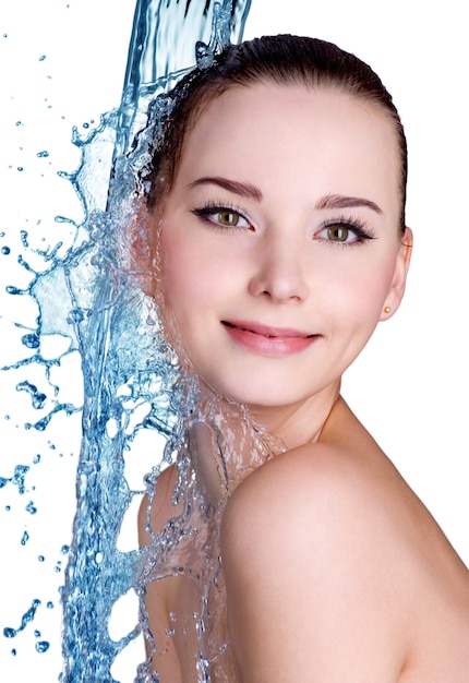 Retrato de uma jovem sorridente com água no rosto e no corpo