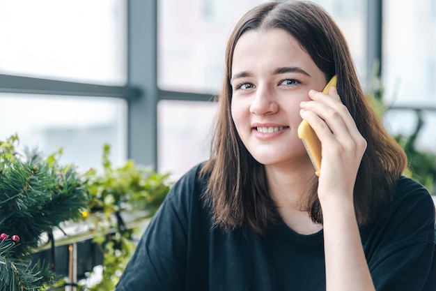 Retrato de uma jovem sorridente, falando ao telefone