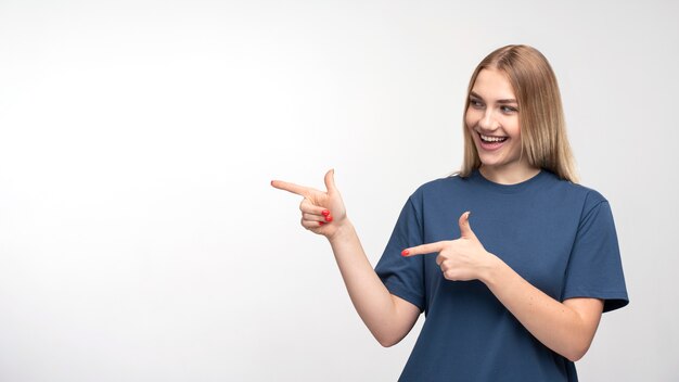 Retrato de uma jovem sorrindo e apontando