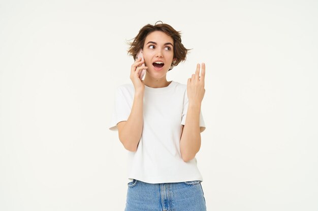Retrato de uma jovem tagarela falando no celular e gesticulando discutindo algo sobre o