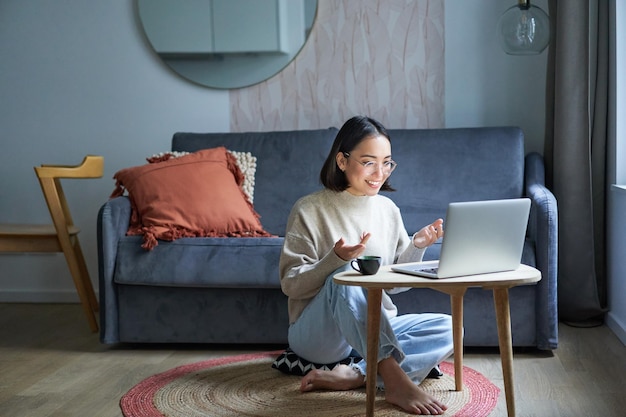 Retrato de uma jovem trabalhadora coreana estudando on-line remota conversando com o bate-papo por vídeo do laptop h