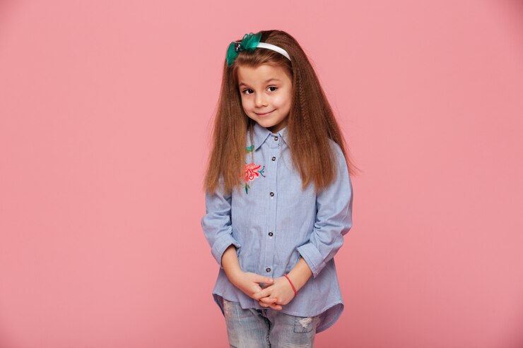 Foto grátis retrato de uma linda garota com longos cabelos ruivos, olhando com um sorriso gentil