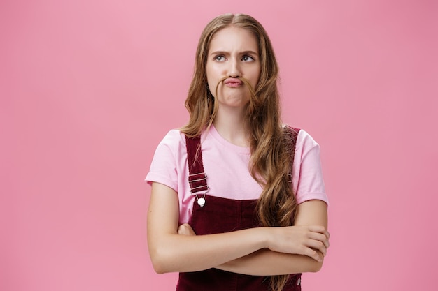 Retrato de uma linda garota engraçada e carismática fazendo bigode de cabelo e cara de boba brincando ...