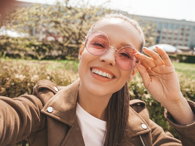 Retrato de uma linda menina morena sorridente no verão hipster roupas jeans e jaqueta