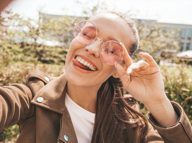 Retrato de uma linda menina morena sorridente no verão hipster roupas jeans e jaqueta