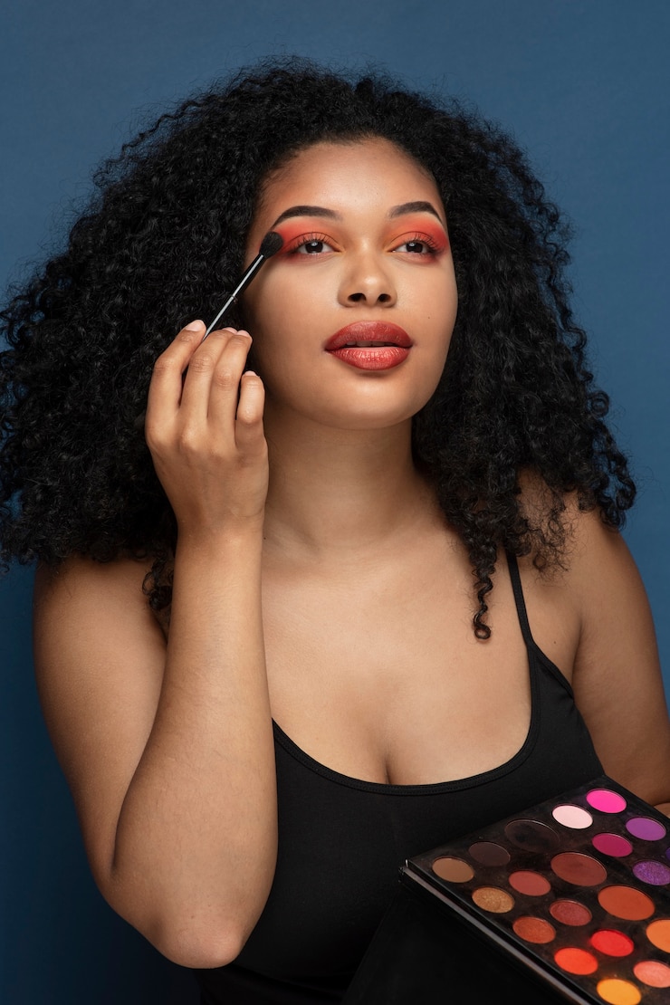 Foto grátis retrato de uma linda mulher aplicando sombra com um pincel de maquiagem