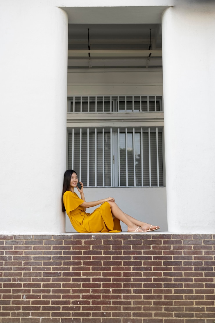 Foto grátis retrato de uma linda mulher asiática usando smartphone ao ar livre na cidade