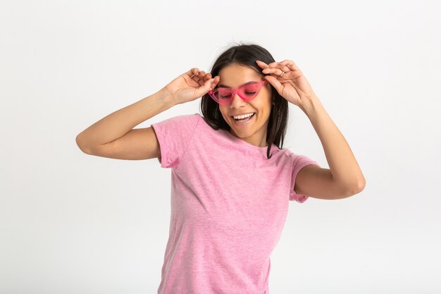 Retrato de uma linda mulher sorridente e emocional de camisa rosa e óculos de sol elegantes, posar positivo isolado