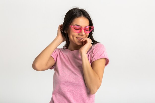 Retrato de uma linda mulher sorridente e emocional de camisa rosa e óculos de sol elegantes, posar positivo isolado