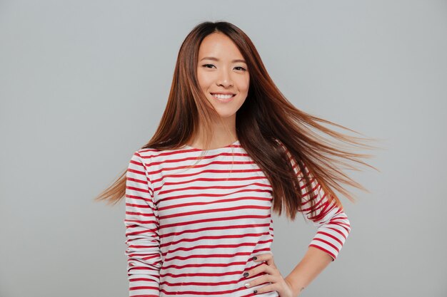 Retrato de uma menina asiática bonita feliz com cabelos longos