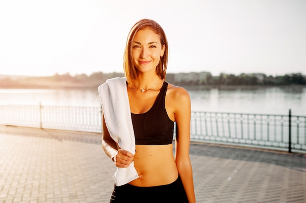 Retrato de uma menina atlética. Modelo de fitness esporte jovem bonita se preparando para fazer jogging no parque da cidade.