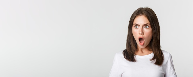 Foto grátis retrato de uma menina bonita impressionada olhando para a mandíbula esquerda e ofegando fundo branco atônito