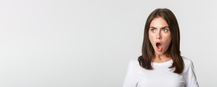 Foto grátis retrato de uma menina bonita impressionada olhando para a mandíbula esquerda e ofegando fundo branco atônito