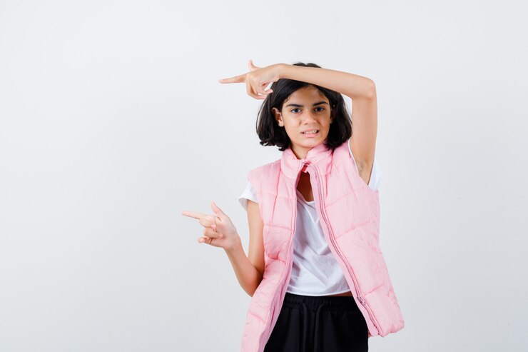 Foto grátis retrato de uma menina com camiseta branca e colete inflável apontando para a esquerda