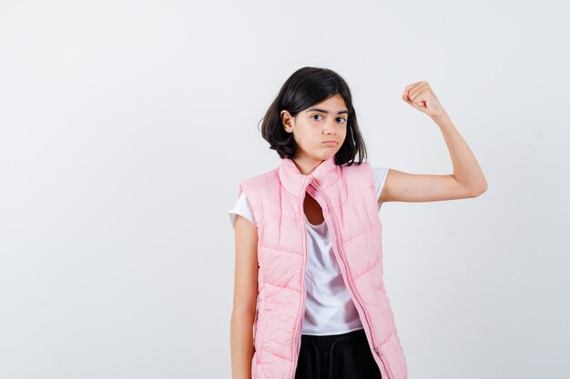 Retrato de uma menina com camiseta branca e colete inflável mostrando os músculos