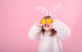 Retrato de uma menina com orelhas de coelho e ovos de páscoa